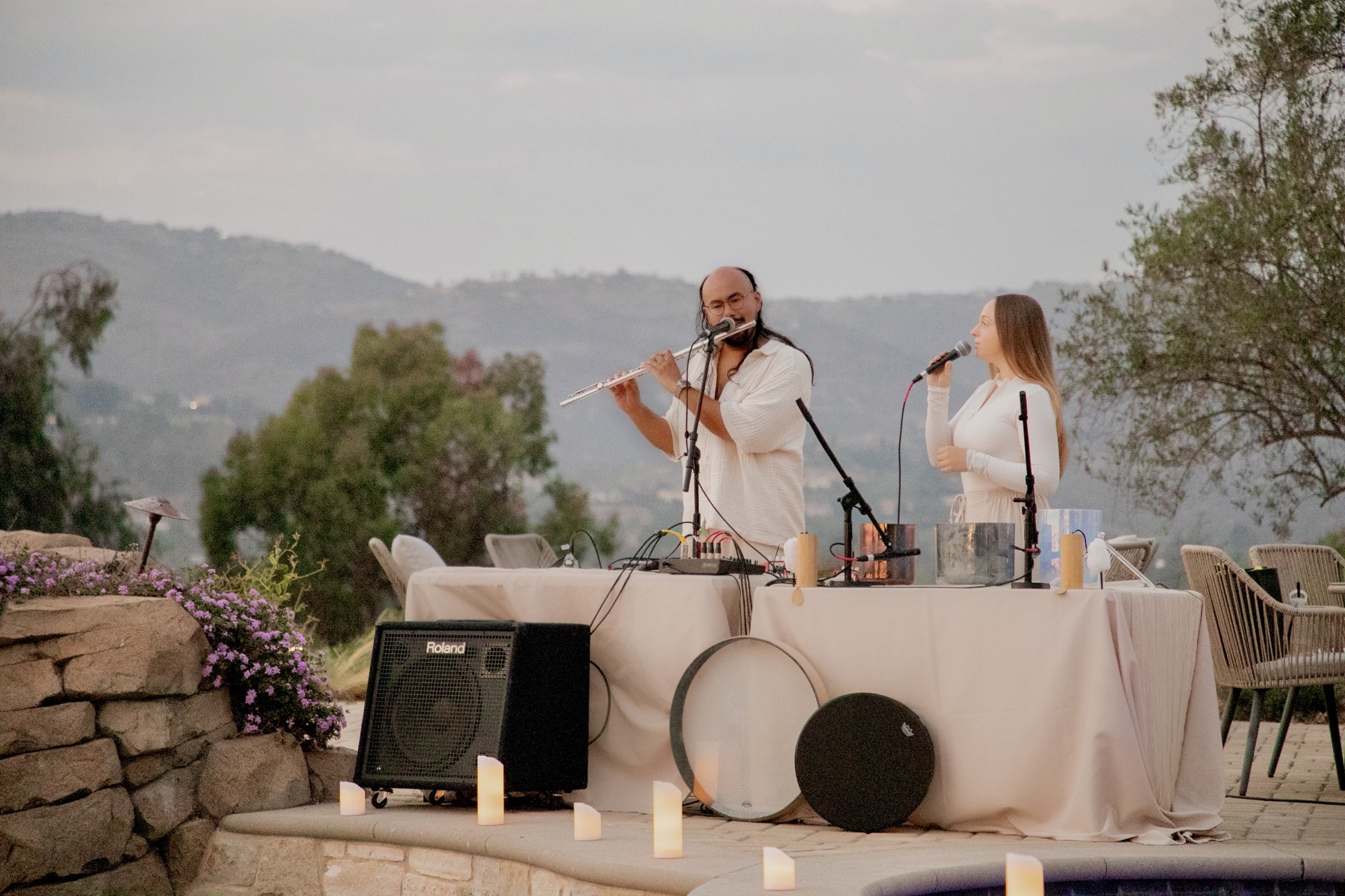 Pure playing flute and Saraswati singing beside alchemy bowls during an outdoor sound bath